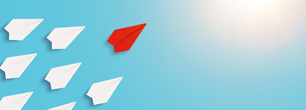 Red origami paper plane flies in front of the white plane. Leadi